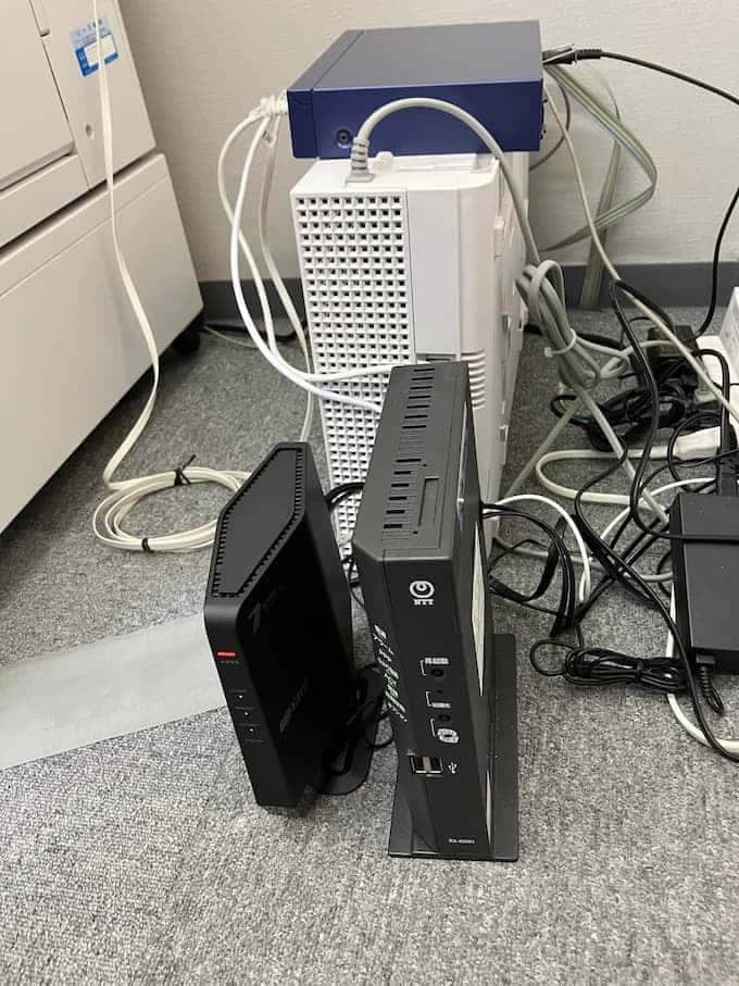 床に設置されたルーターとモデム、配線コード